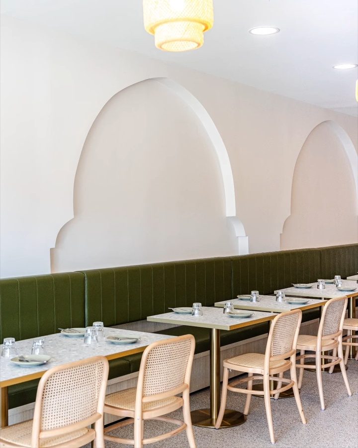 Arched walls above the olive green banquette and set tables in Five Dock