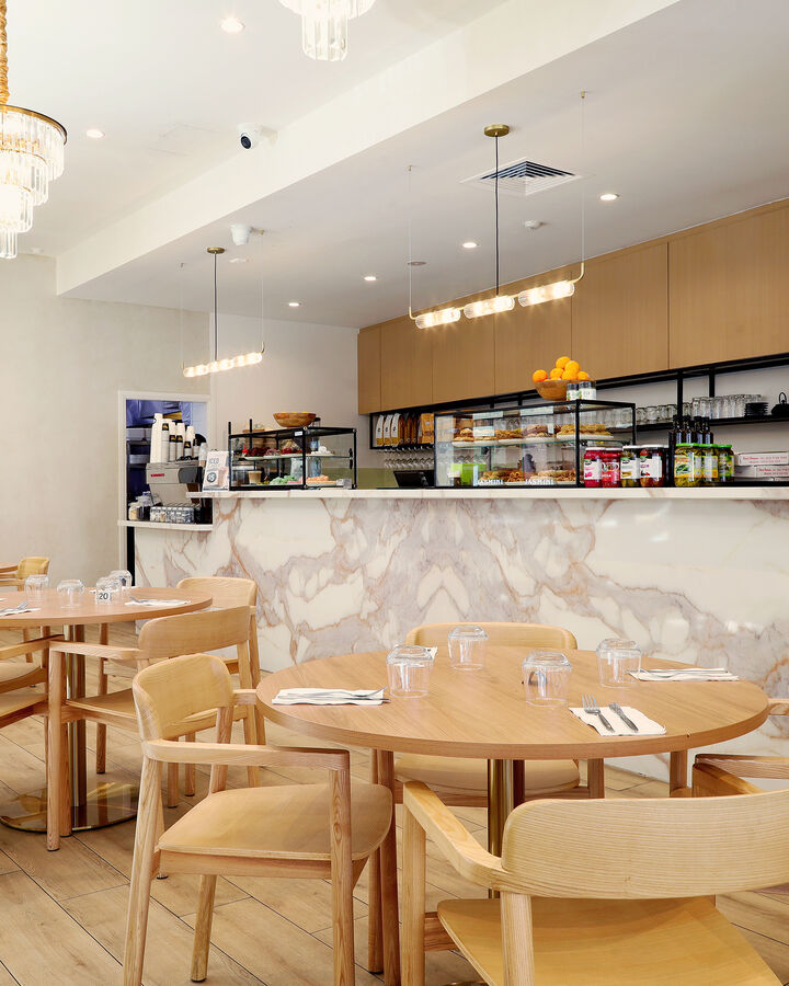 The marble front counter and round timber tables