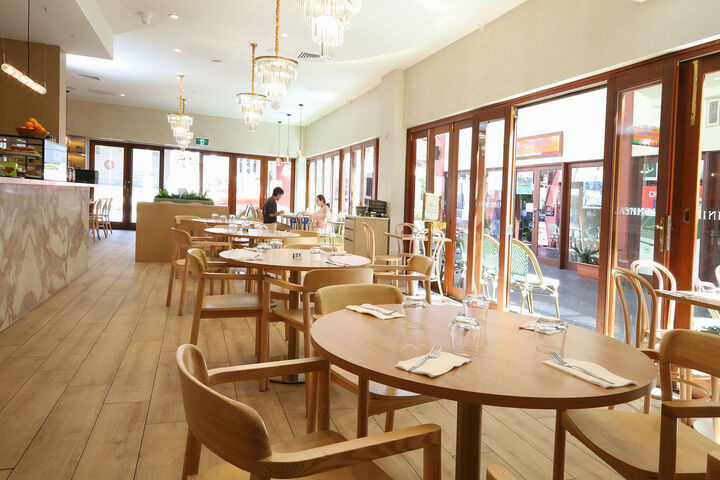 The Leichhardt dining room with round timber tables and crystal chandeliers